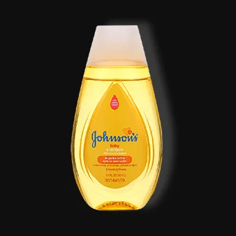 This image shows a bottle of Johnson's Baby Shampoo against a black background. The bottle is transparent with a golden-yellow liquid inside, featuring the brand's logo and signature "No More Tears" label